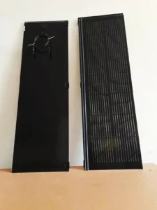 Front and back view of sleek black BIPV solar roofing tiles showing tempered glass surface and rear wiring.