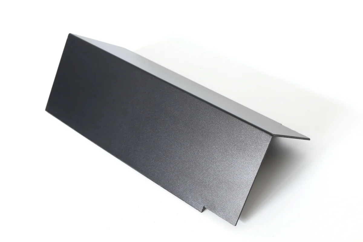 Folded black metal rake tile for finishing the sloping edge of a solar roof.