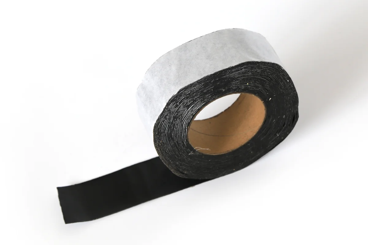 Black butyl sealant tape roll with foil backing for solar roof waterproofing.