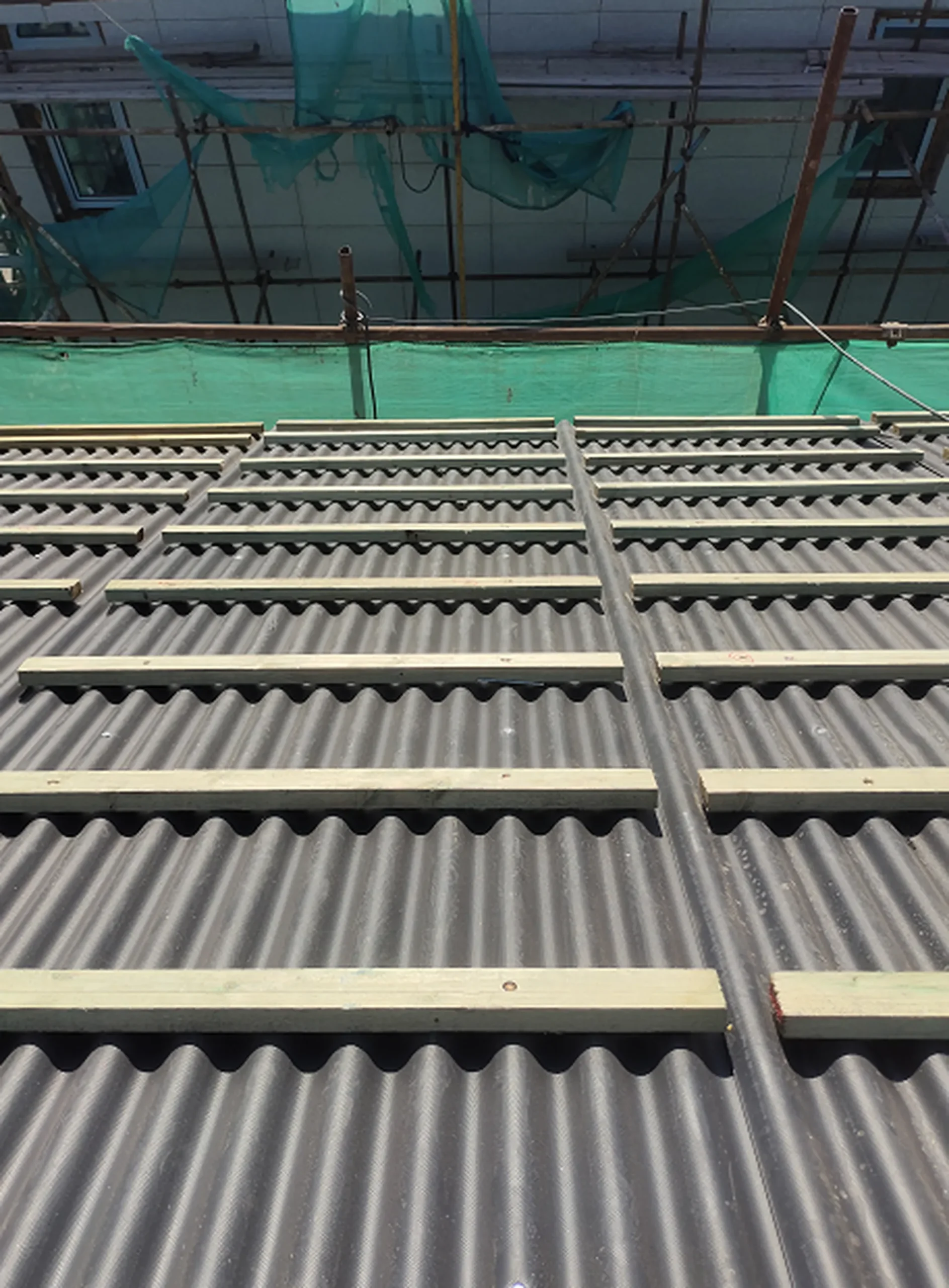 Corrugated waterproof underlayment and wooden counter battens prepared for the BIPV mounting system.