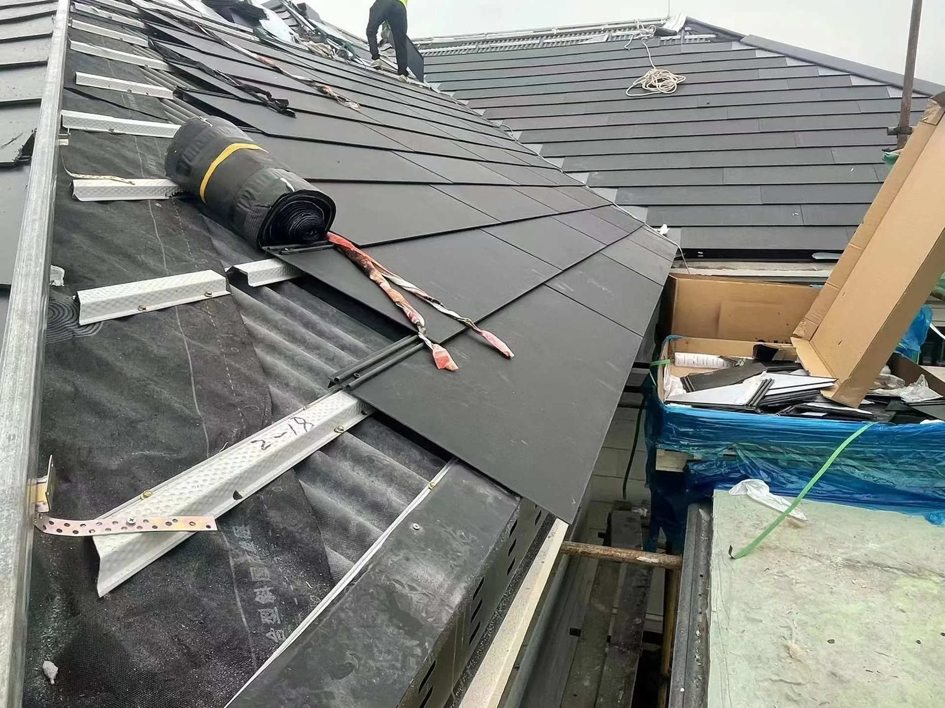 Installation process of the BIPV solar roof showing the specialized mounting battens and waterproof underlayment.