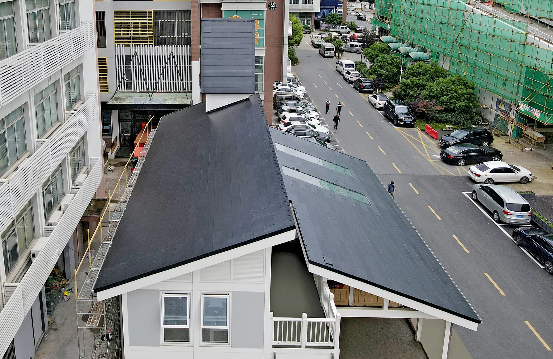 Aerial top-down view showing the precise T-shape intersection of the BIPV roof tiles on the tech demo building.