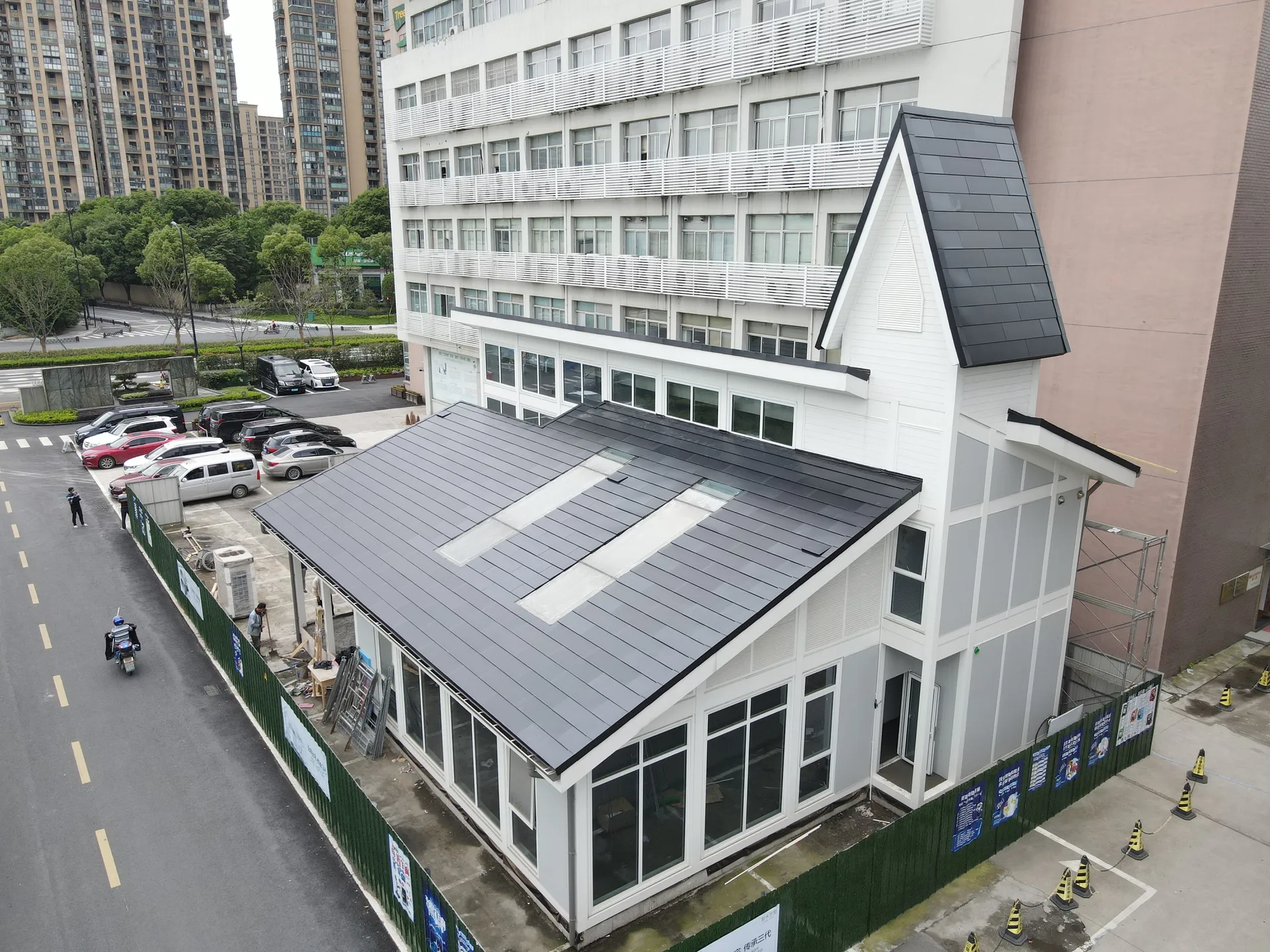 Elevated street view of the commercial tech building showcasing the seamless invisible solar roofing design.