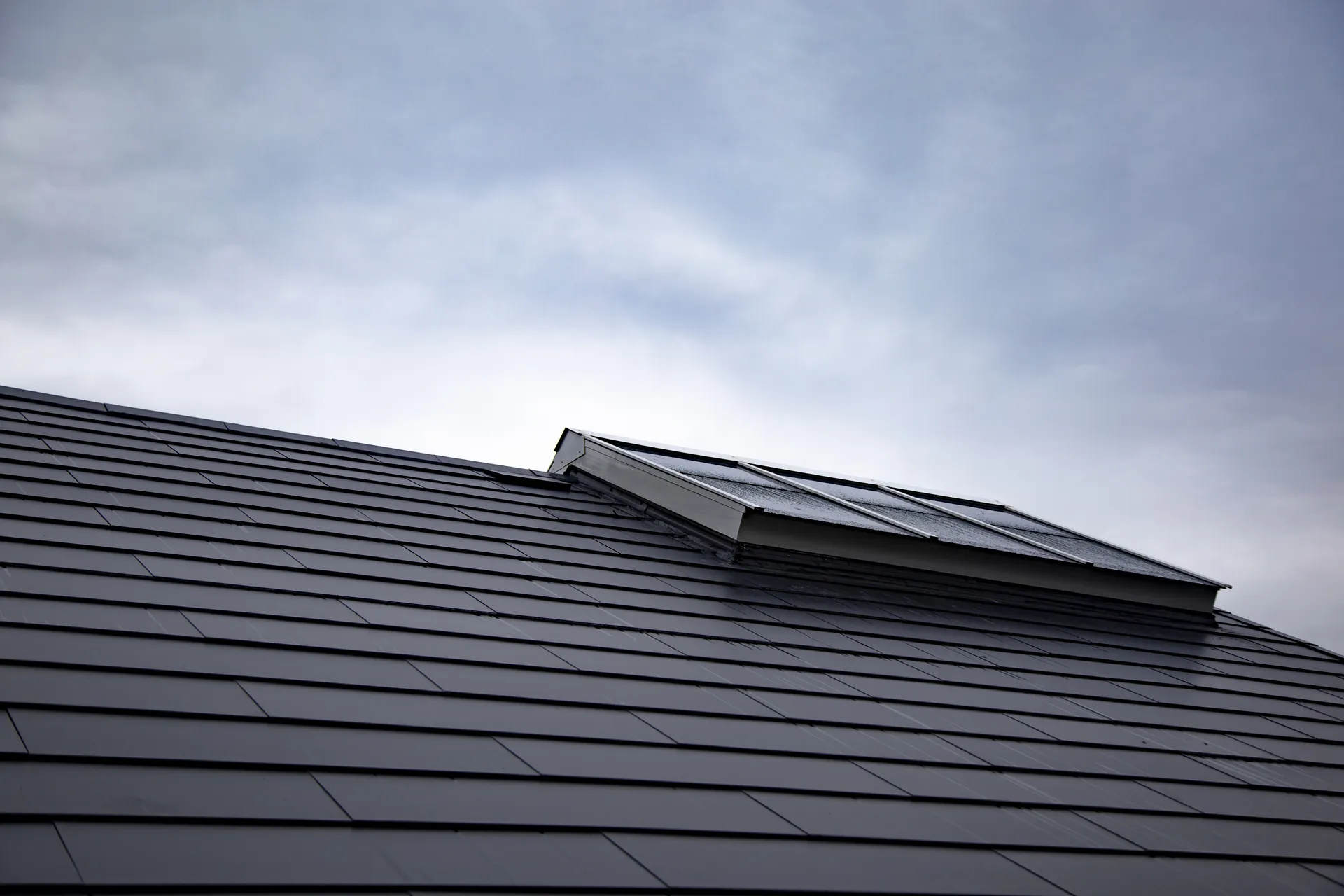 Solar roof tile installation detail showing tile integration and skylight