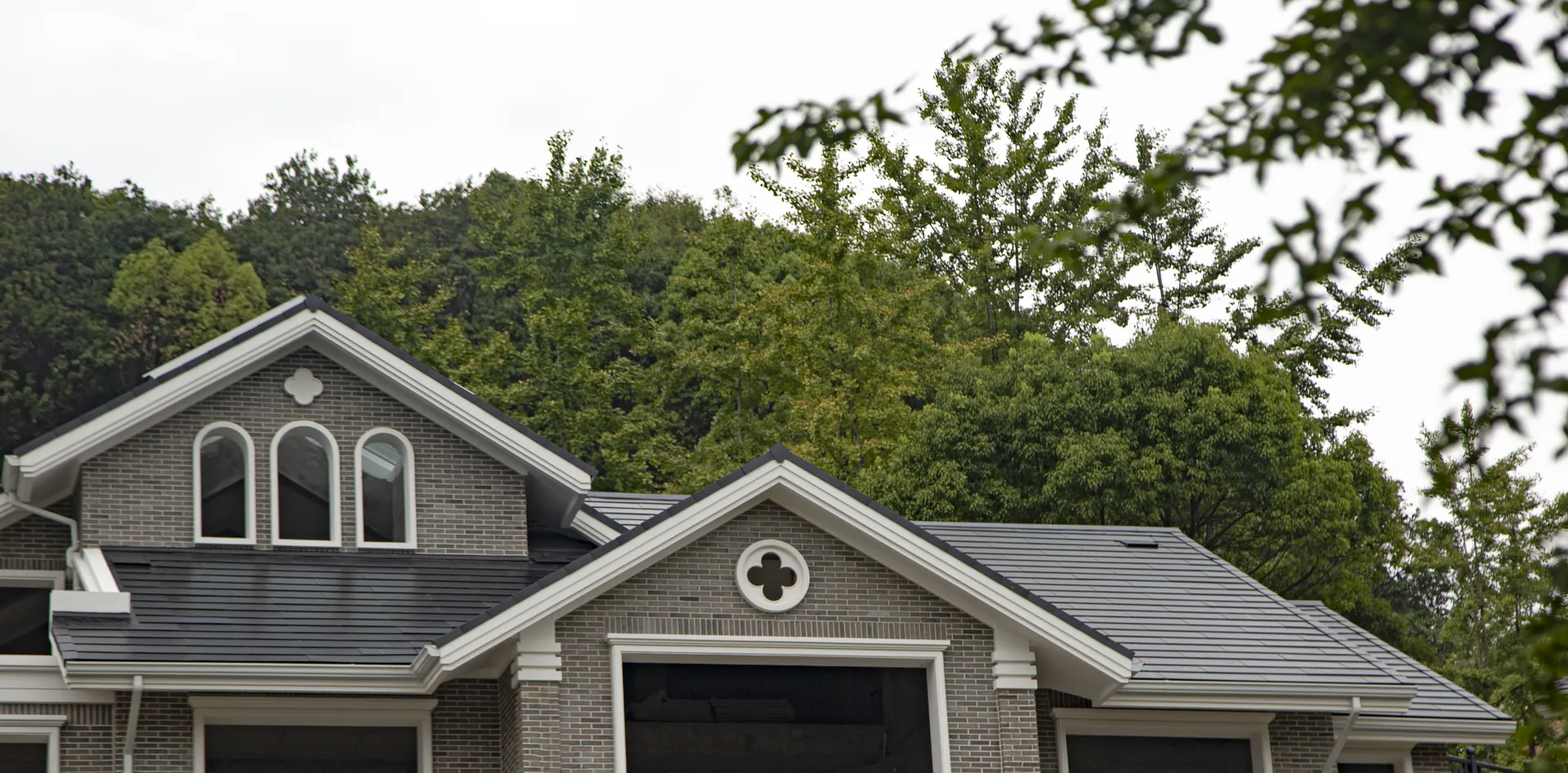 Aerial view focusing on the precise integration of large skylights within the Sunlit solar slate roof system.
