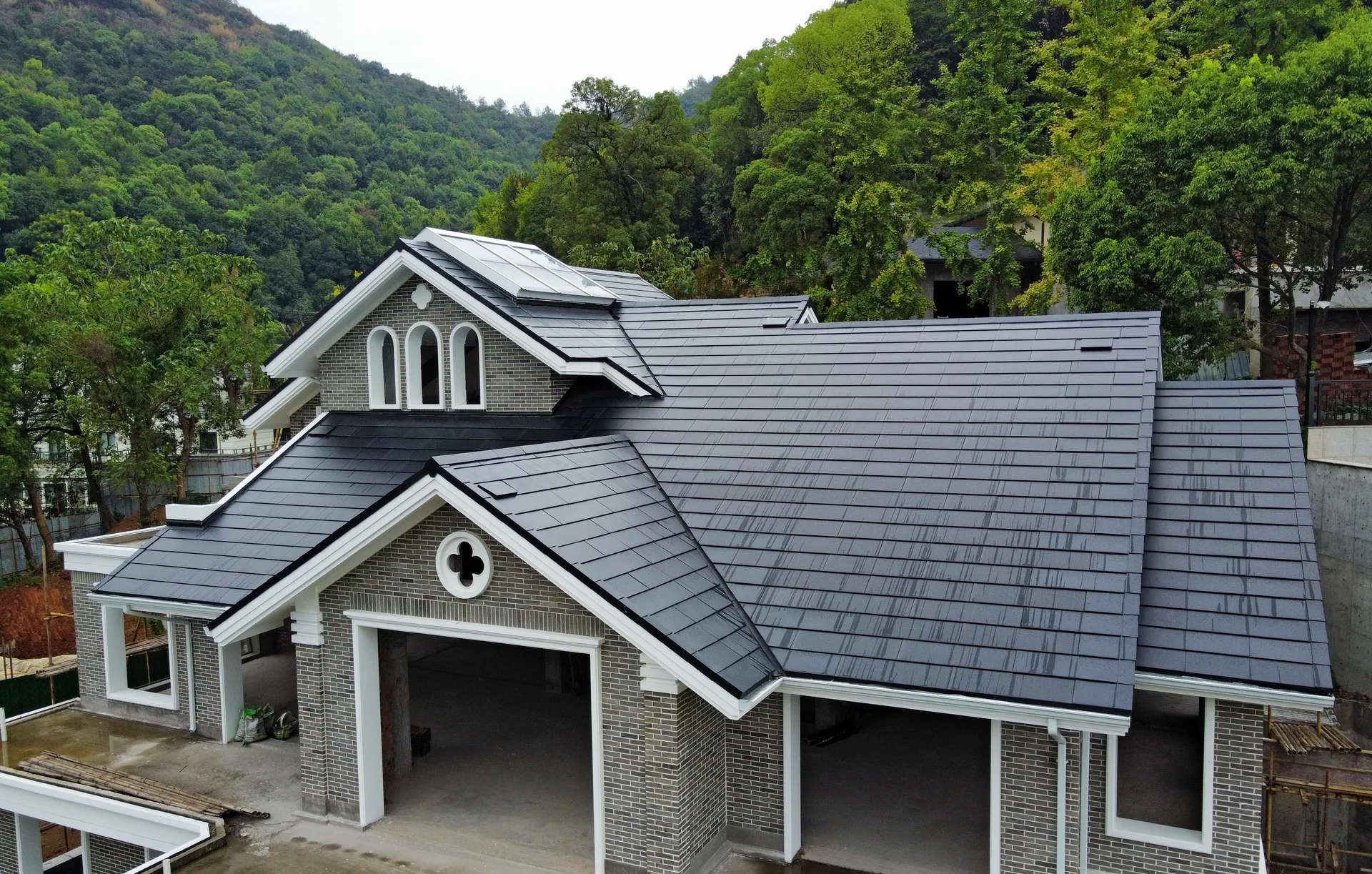 Close-up details of the seamless edge finish of Lumina Slate roof tiles on a traditional grey brick villa.