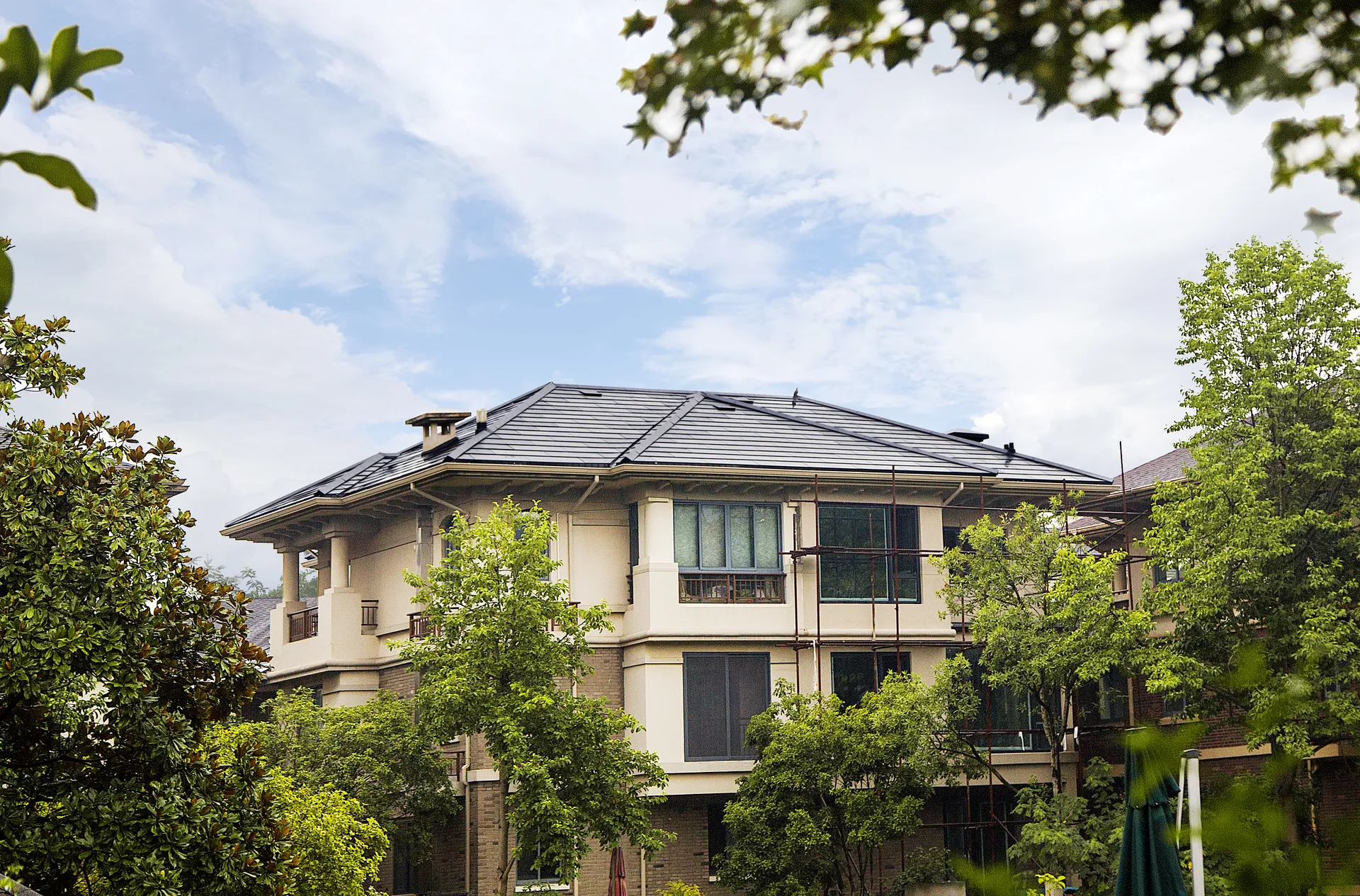 Wide shot of a luxury villa in Hangzhou Yunxi Diegu, featuring the newly installed Sunlit BIPV solar roof surrounded by lush greenery.