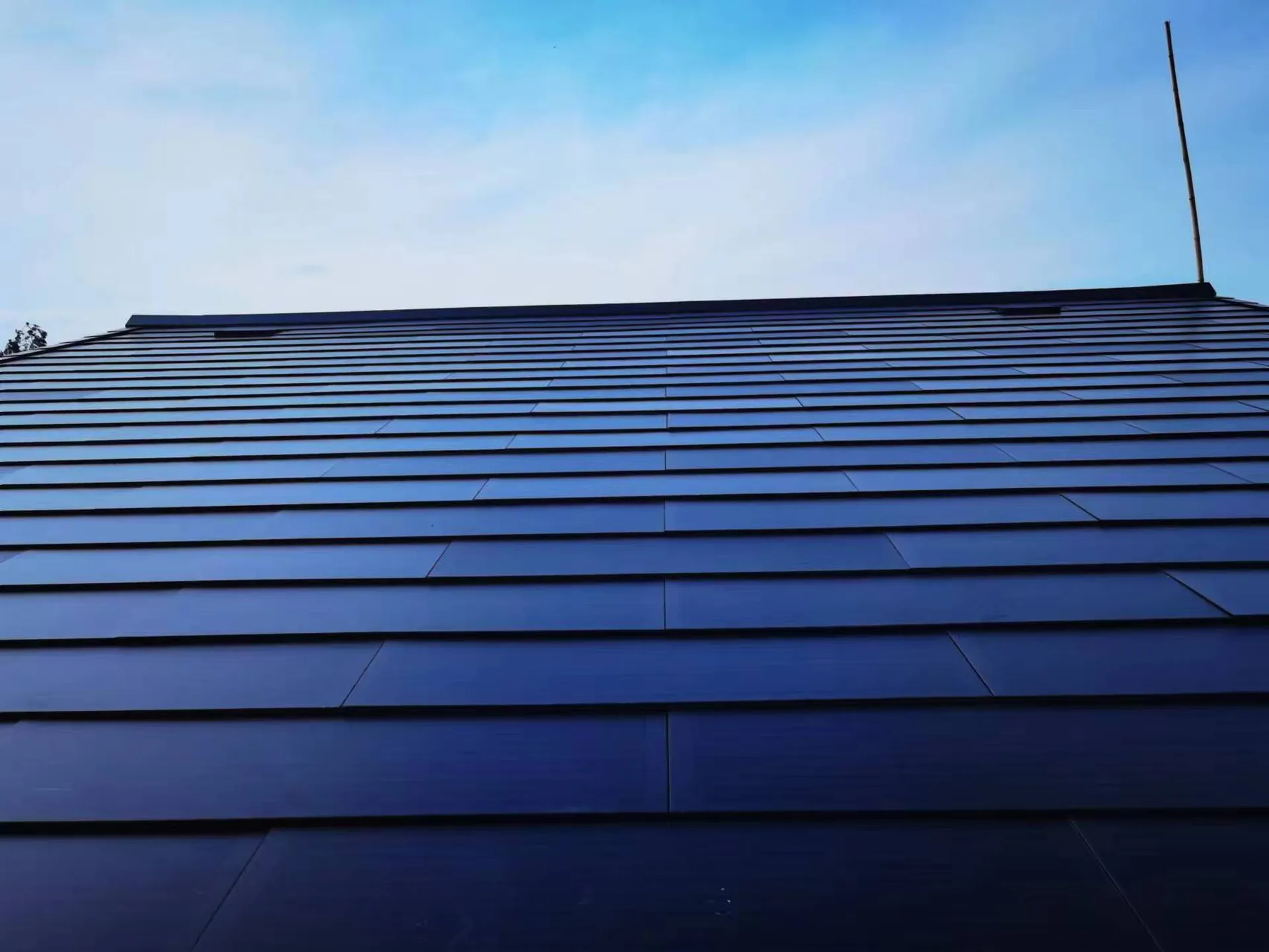 Low-angle view showcasing the sleek, continuous surface and premium aesthetic of the Lumina Slate invisible solar roof.