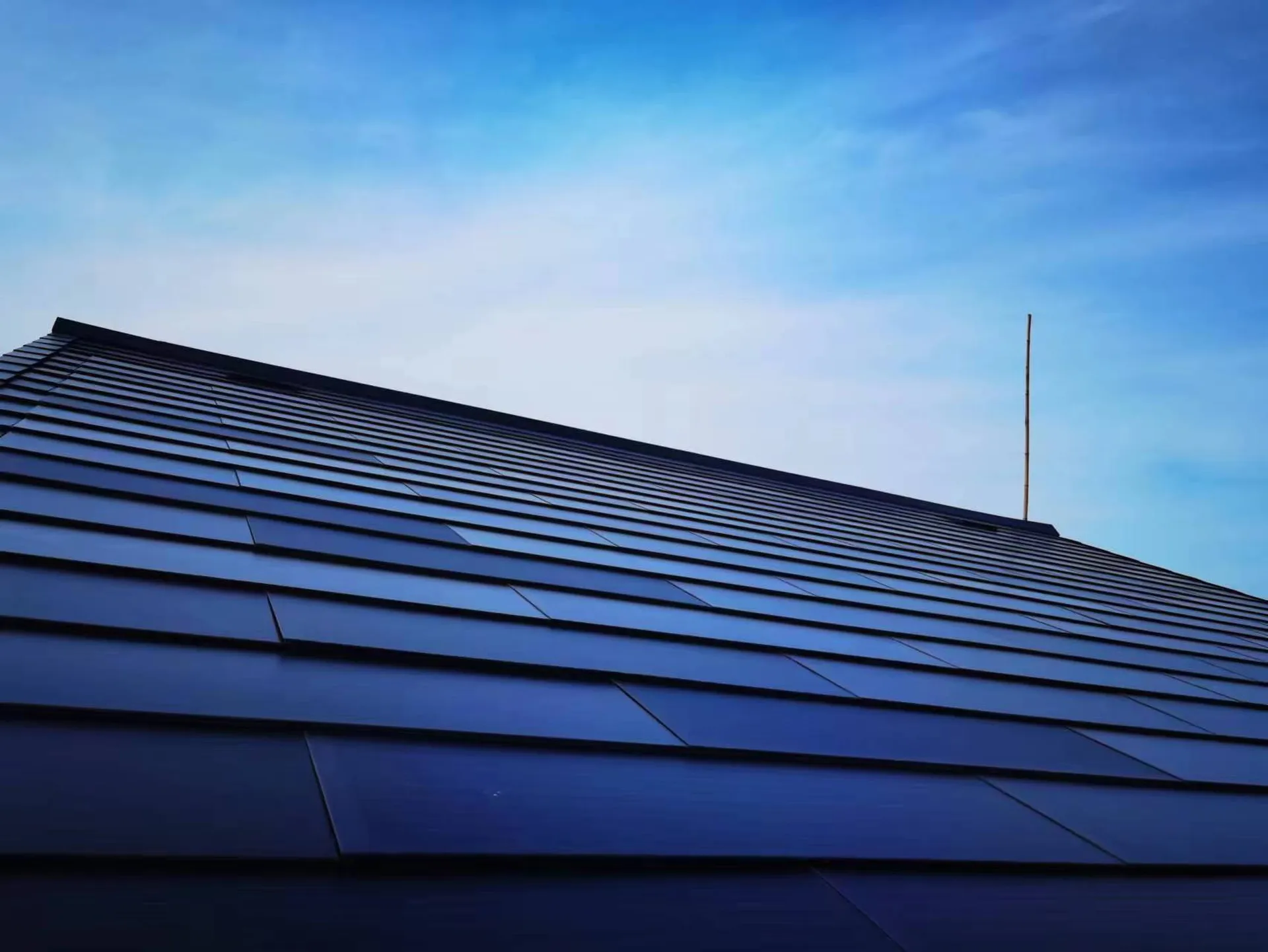 A pristine expanse of Sunlit solar tiles installed on a guesthouse, providing clean energy without compromising architectural beauty.