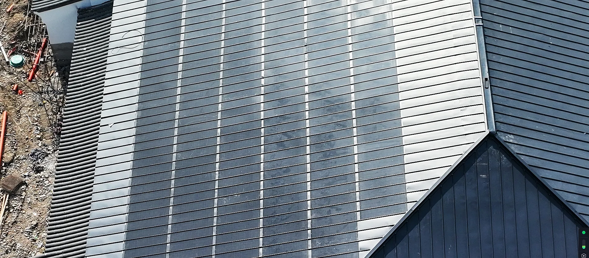 Detailed aerial view of heavy-duty Storm Guard solar tiles seamlessly integrated into a massive commercial building complex.