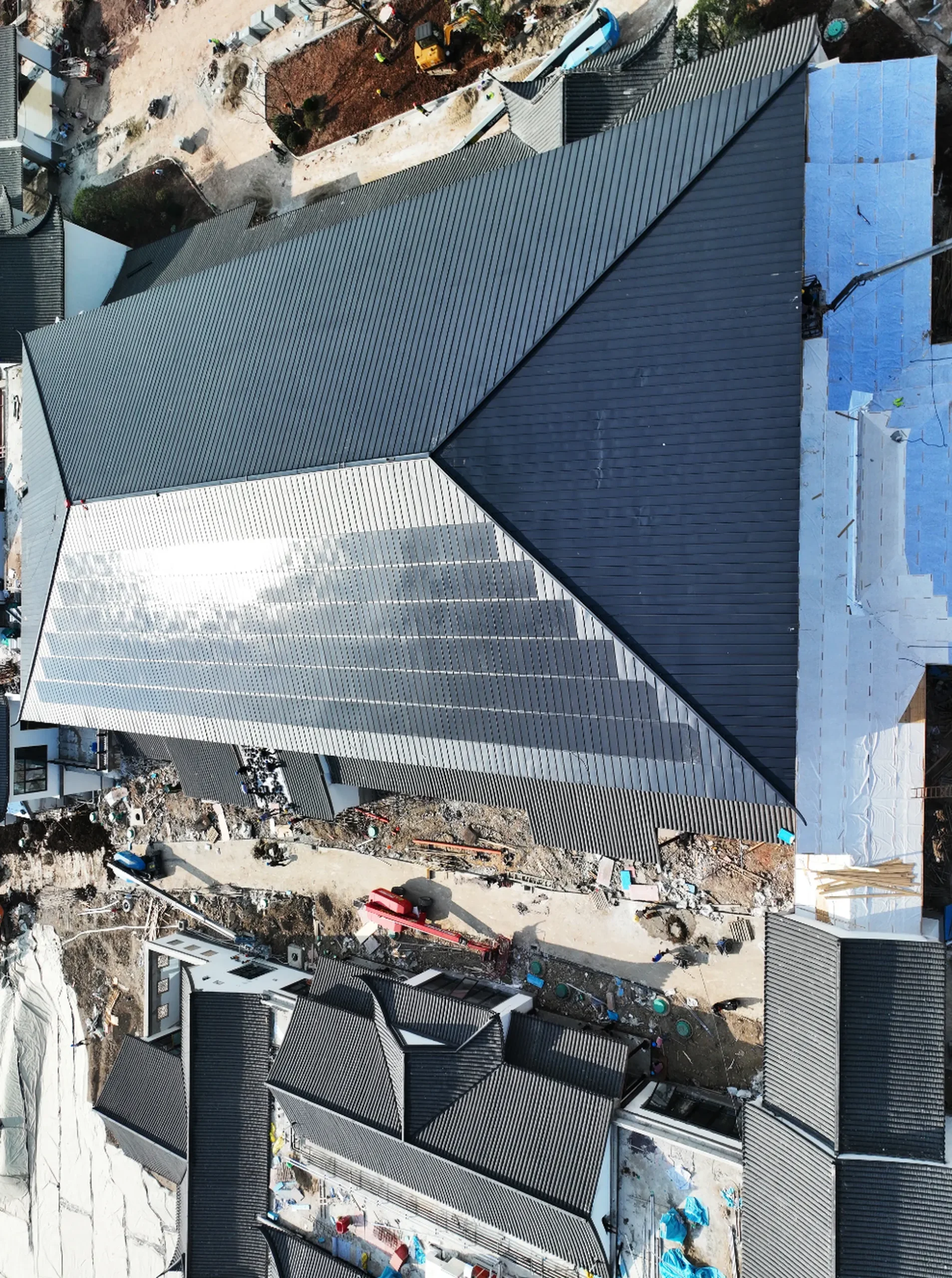 Wide drone shot of a large-scale commercial site installing a hurricane-resistant Storm Guard solar roof system.