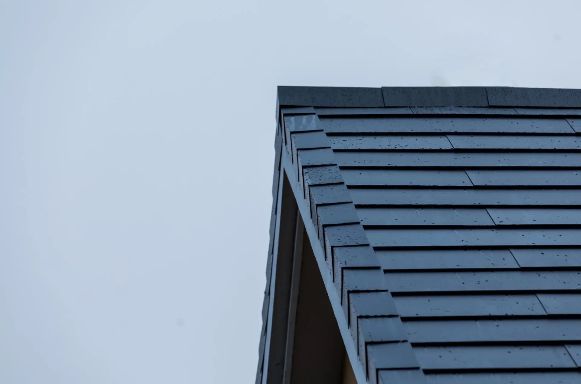 Close-up of the clean gable edge finish of the Sunlit BIPV roof against the sky, showing precise architectural lines.