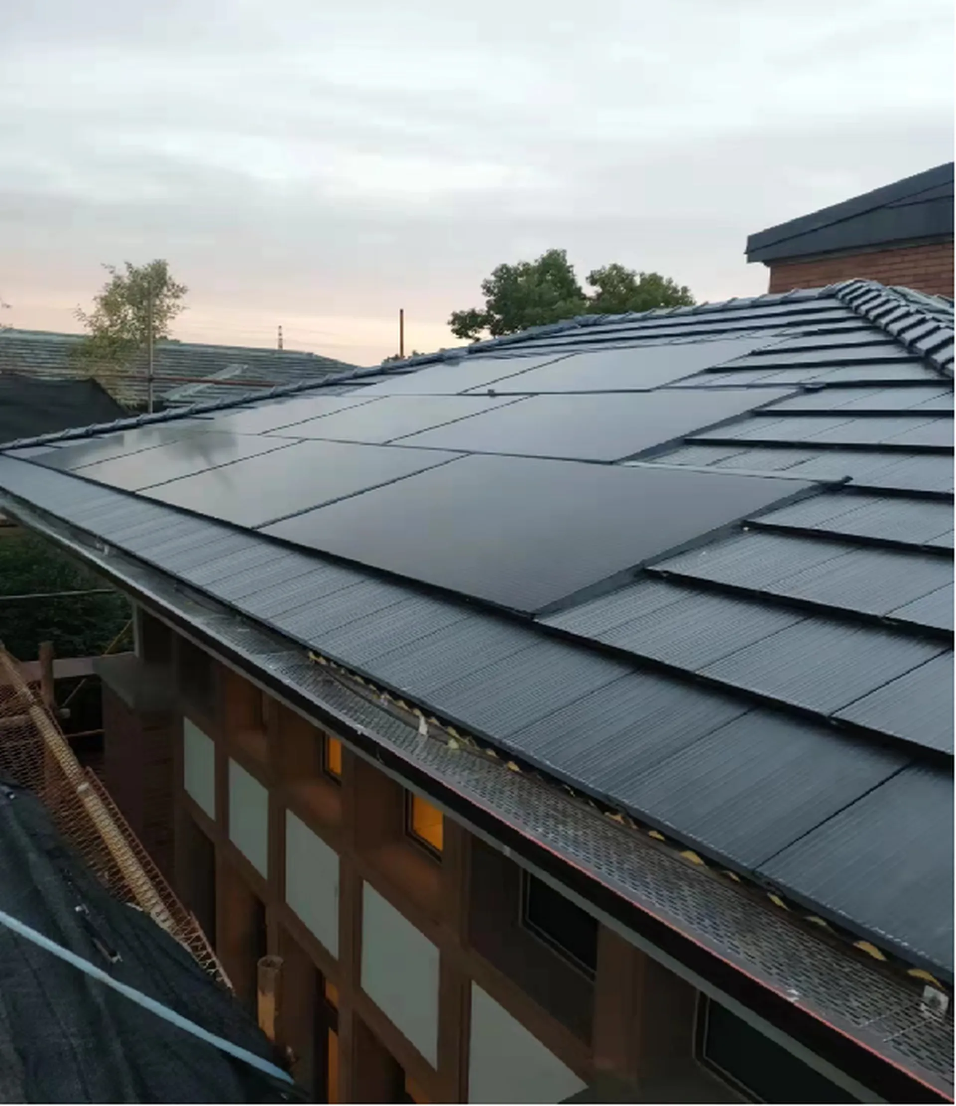 Close-up of an early pioneer BIPV retrofit, demonstrating the integration of solar modules with traditional roofing tiles.