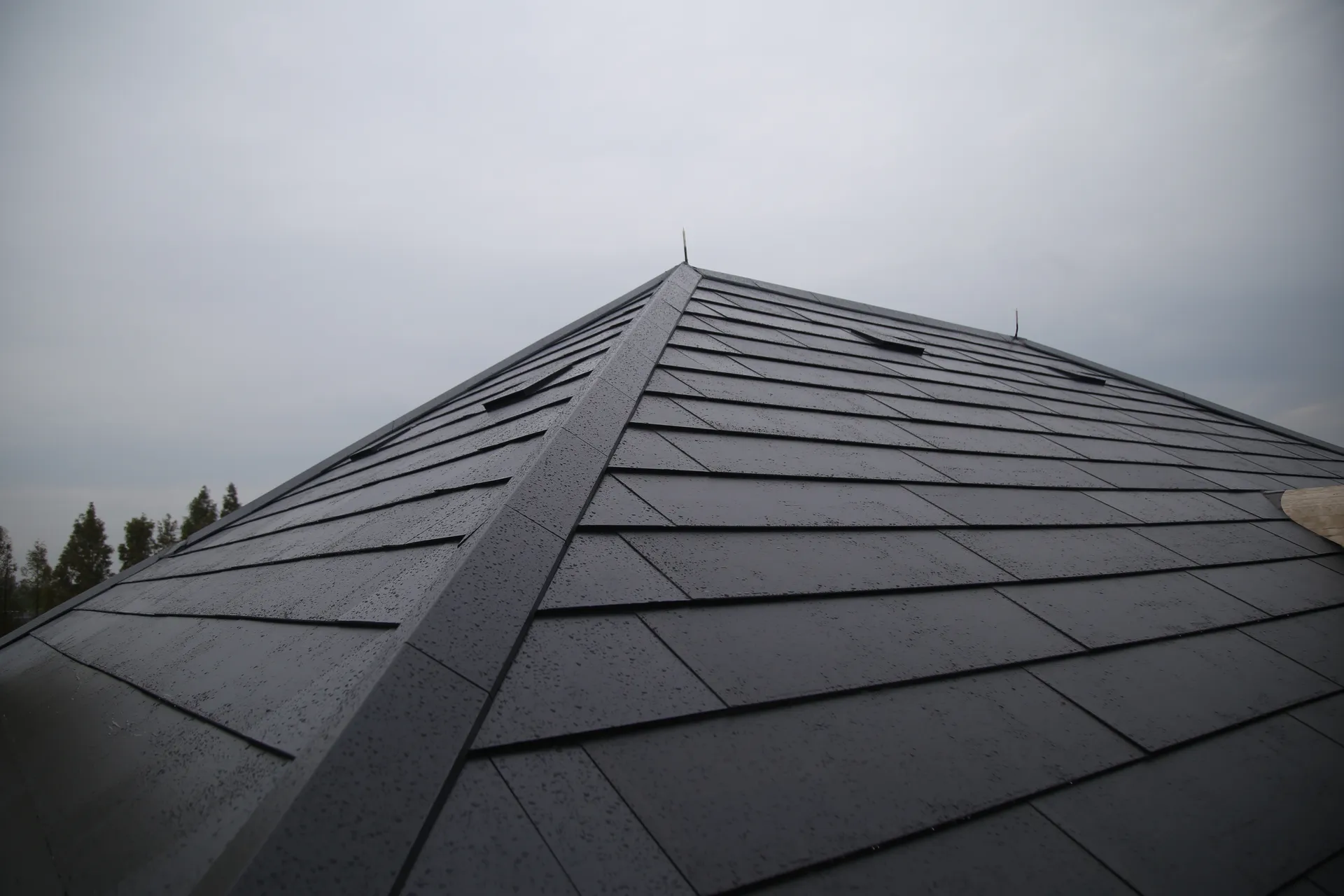 Detailed view of the precise hip ridge capping on the Sunlit solar tile roof, ensuring seamless edge-to-edge protection.