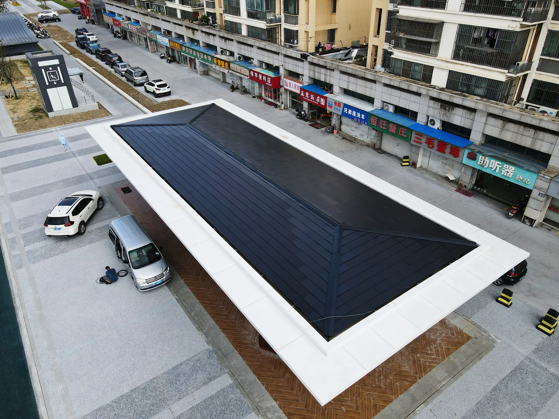 Elevated view of a commercial public pavilion powered entirely by a flush-mounted solar roof.