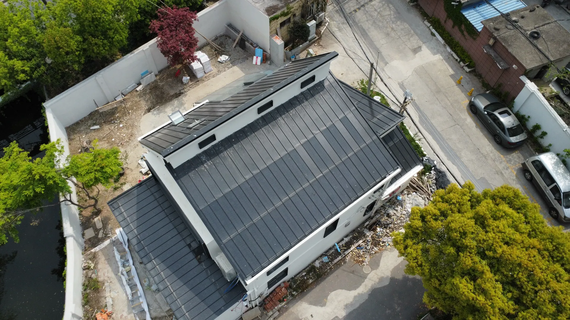 Aerial view of a compact, typhoon-resistant Storm Guard solar roof in a dense urban neighborhood.