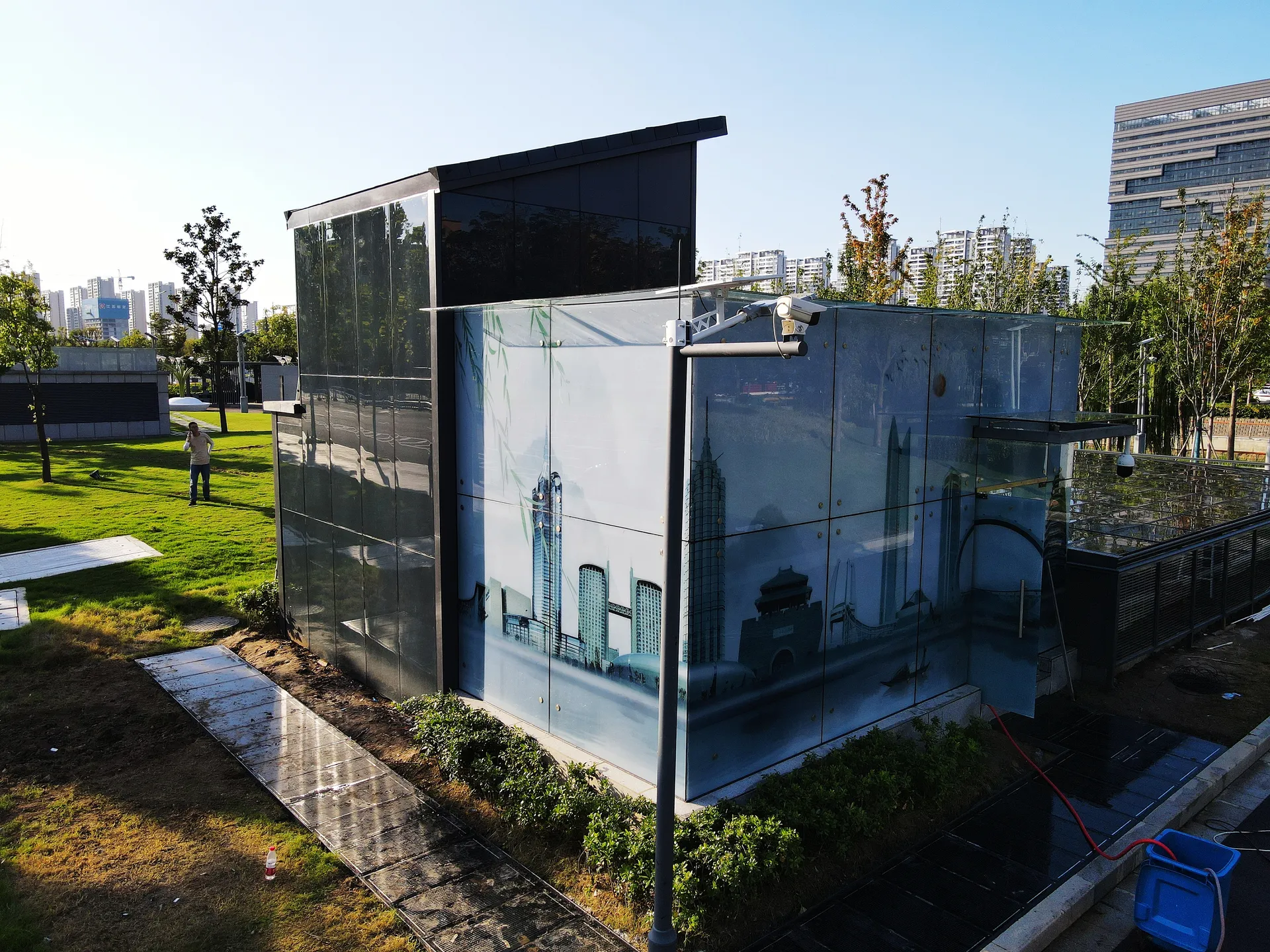 Ground view of the BIPV energy station featuring custom-printed solar glass facades blending with the environment.