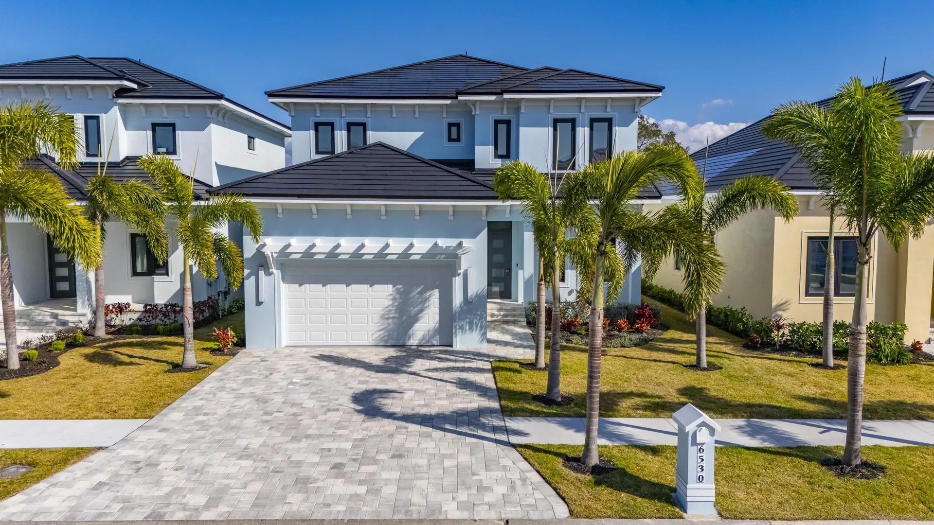 Street-level view of newly developed coastal homes, demonstrating how BIPV solar roofs enhance neighborhood curb appeal.