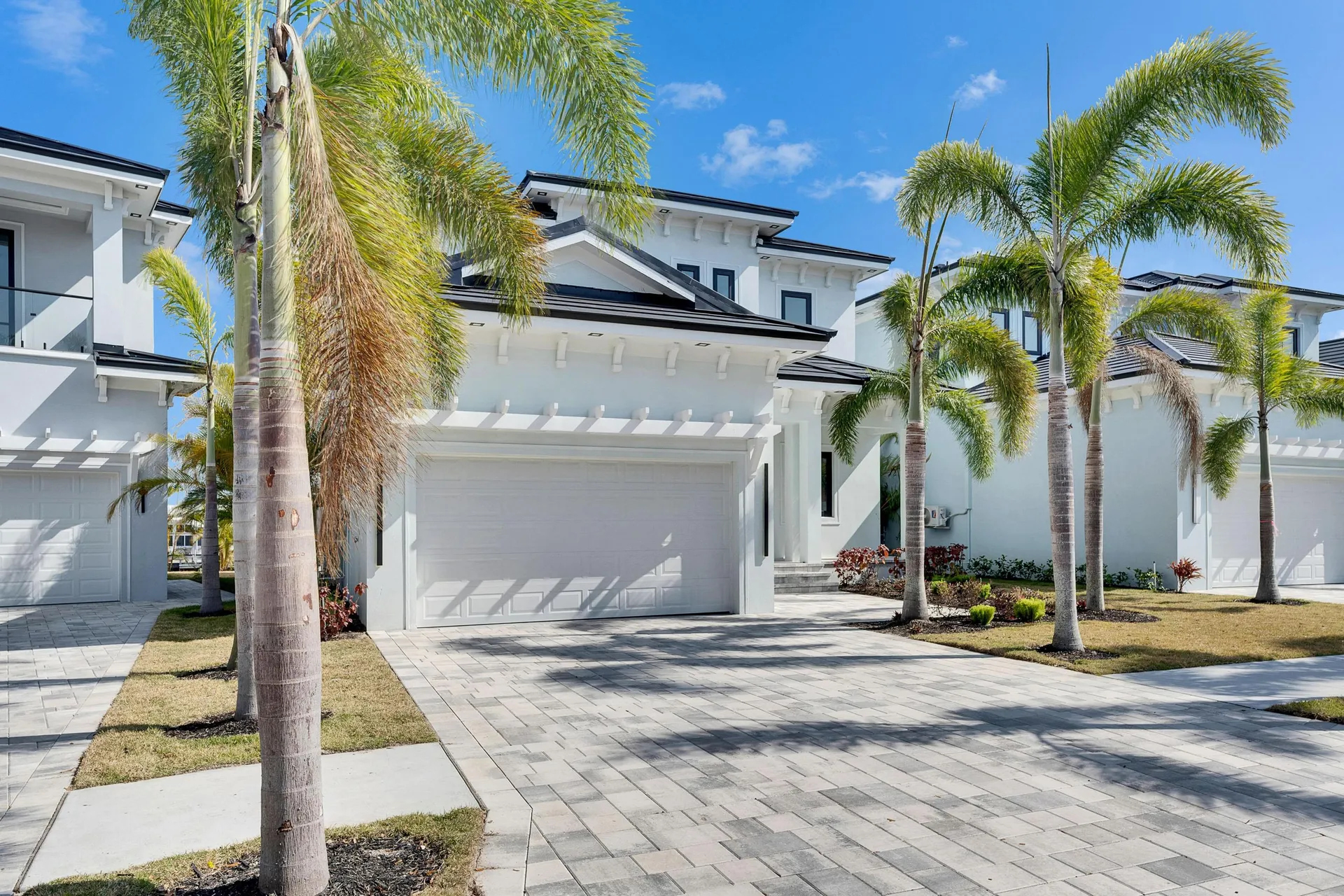 A beautiful white coastal villa seamlessly integrating a dark, high-efficiency solar roof into its modern architecture.