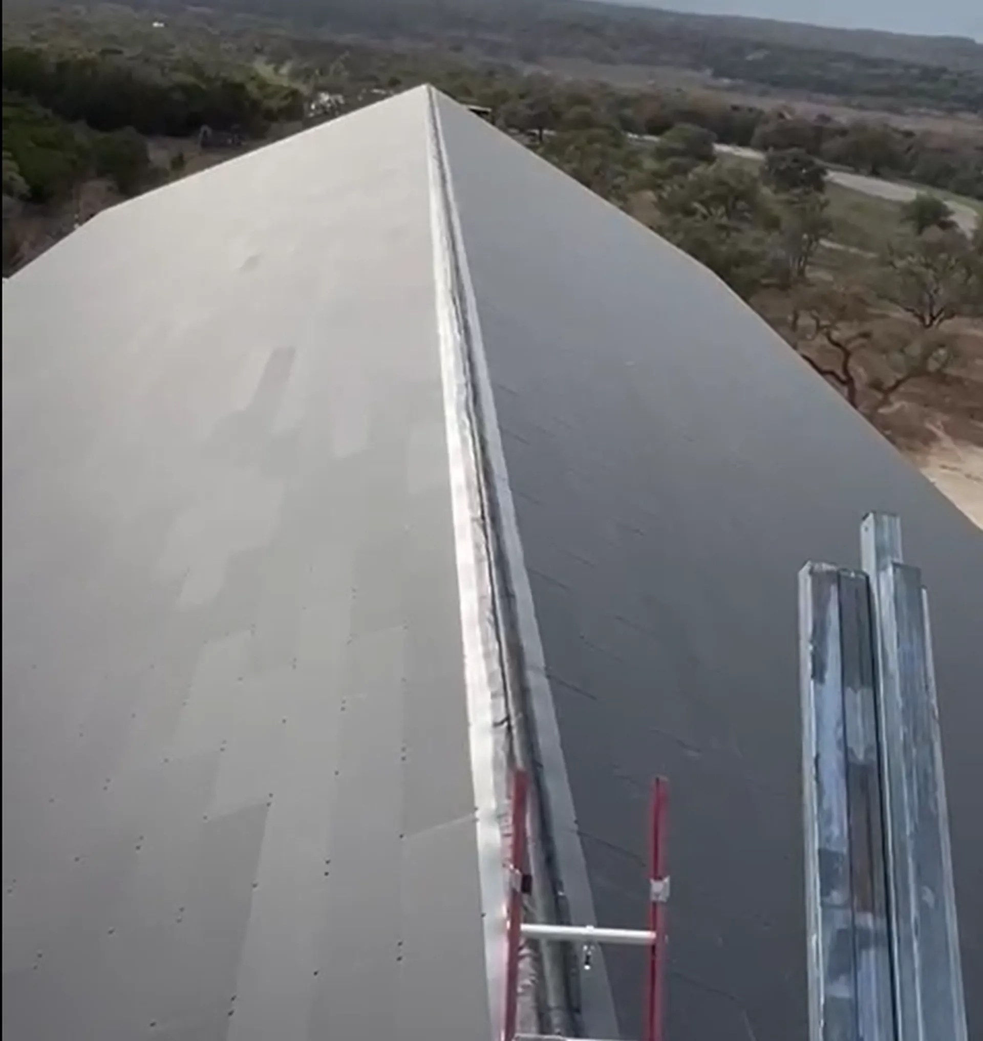 Wide drone view of the large USA gymnasium under construction, showing scaffolding and active building site infrastructure.