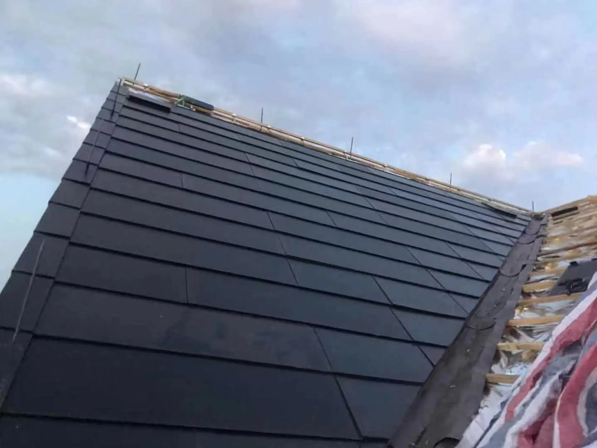 Edge installation detail of the Sunlit solar roof showing the waterproof underlayment and structural transition.
